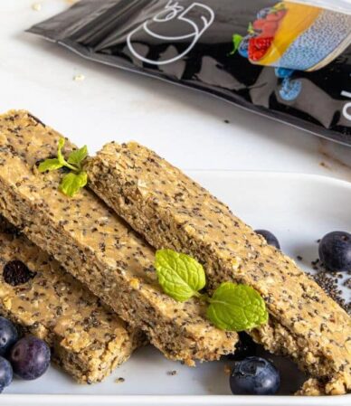 Domowe batony zbożowe z nasionami chia, borówkami i miętą ułożone na białym talerzu obok opakowania nasion chia Quality Food.